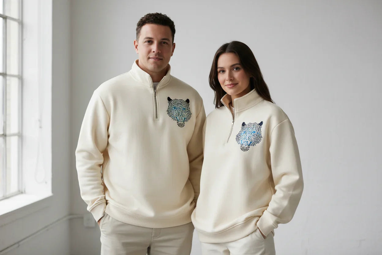 Unisex cream quarter-zip sweatshirt with blue jeweled leopard design, soft knit fabric, Comfy Elegance