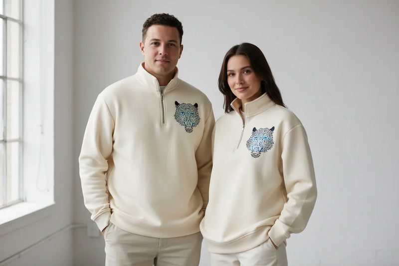 Unisex cream quarter-zip sweatshirt with blue jeweled leopard design, soft knit fabric, Comfy Elegance